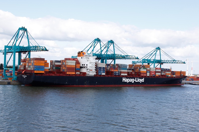 Zwart met rood containerschip van Hapag-Lloyd met vele gestapelde containers.
