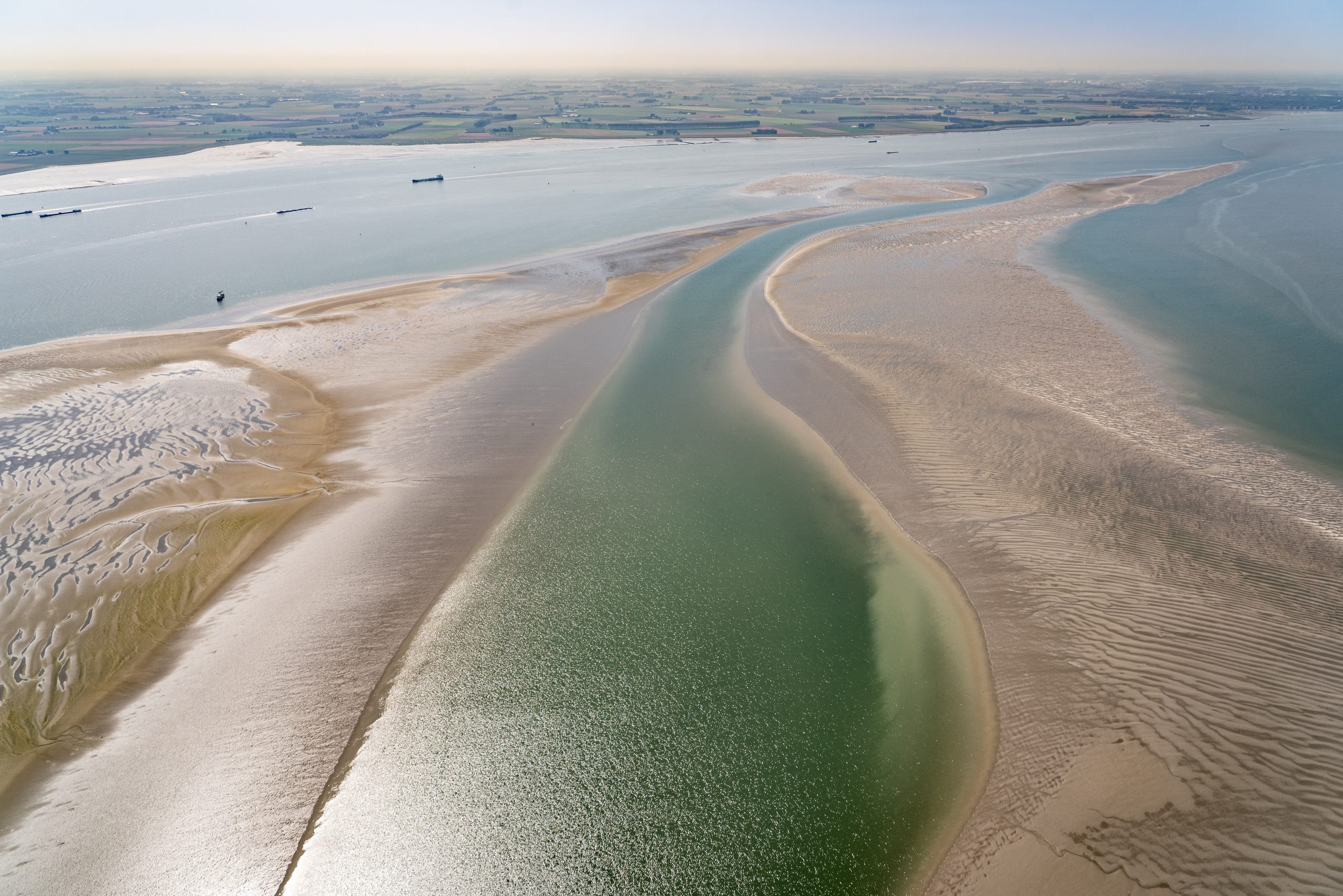 Afbeelding met een water, met zand aan beide kanten.