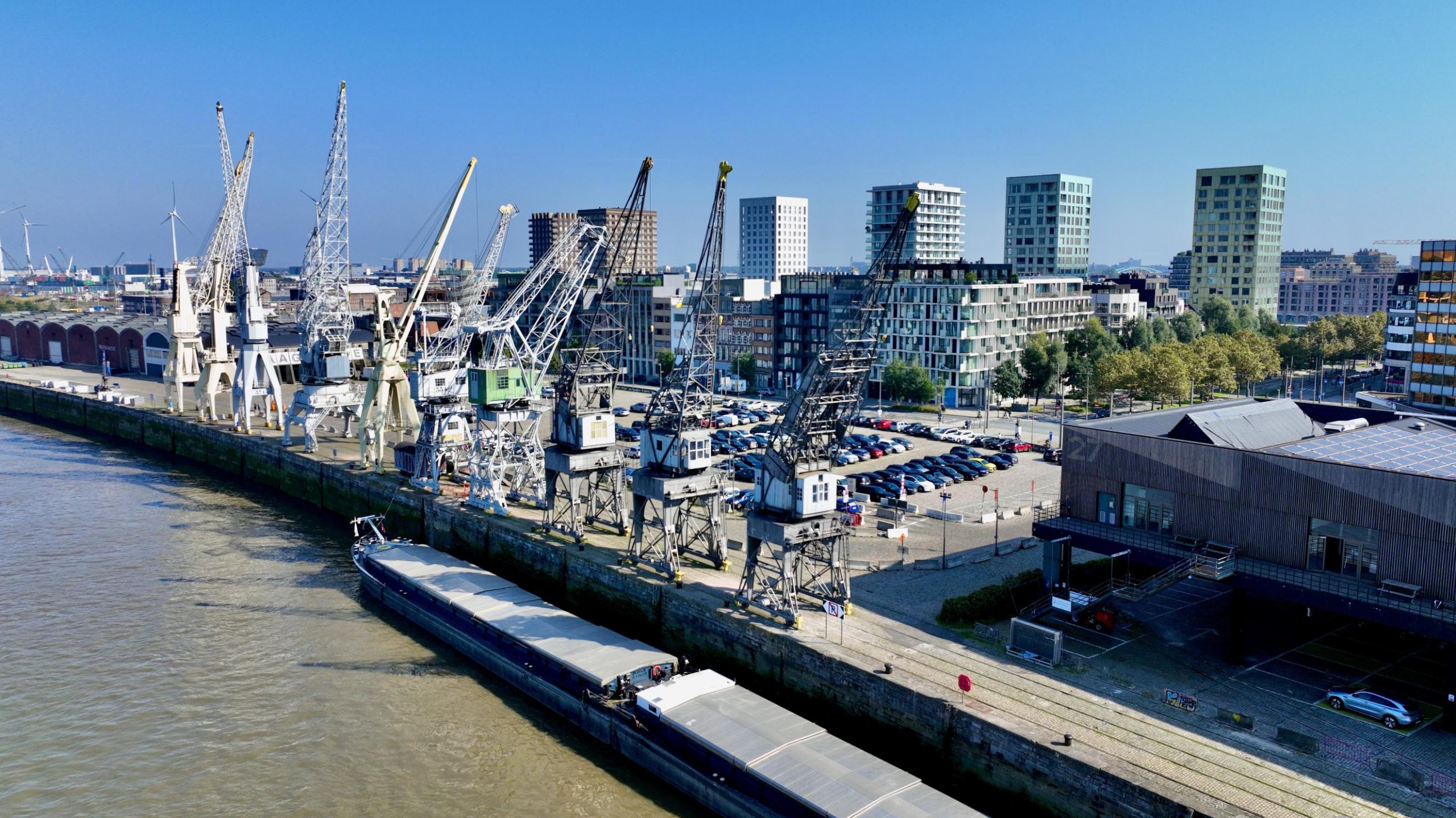 Rijnkaai met hijskranen en woningen op de achtergrond